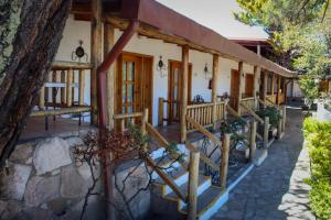 a house with a staircase leading to the front porch at Hotel Divisadero Barrancas in El Divisadero