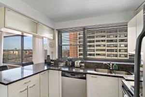 a kitchen with a sink and a large window at Spacious & Modern 2BR Apartment - Algonquin 06-008E in Chicago