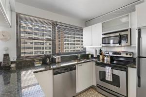 a kitchen with white cabinets and stainless steel appliances at Spacious & Modern 2BR Apartment - Algonquin 06-008E in Chicago