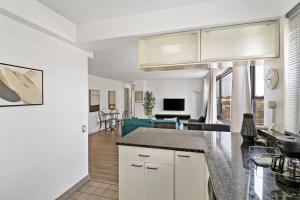 a kitchen with a counter top and a living room at Spacious & Modern 2BR Apartment - Algonquin 06-008E in Chicago