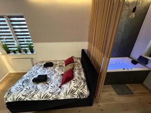 a small bed in a room with a tub at Ocean Black jacuzzi in Kraków