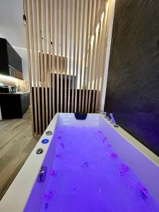 a large purple bath tub in a bathroom at Ocean Black jacuzzi in Kraków