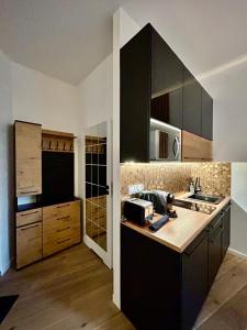 a kitchen with black cabinets and a counter top at Ocean Black jacuzzi in Kraków