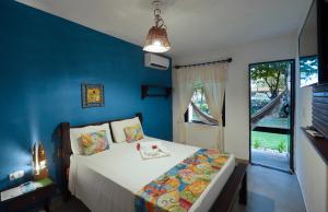 Schlafzimmer mit einem Bett mit blauer Wand in der Unterkunft Pousada dos Coqueiros in Porto De Galinhas