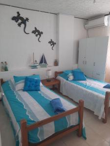 two beds in a room with blue at Edificio Santa Catalina in San Andrés