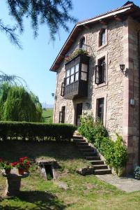 an old stone building with a balcony and flowers at El Molino de Cicera in Cicera