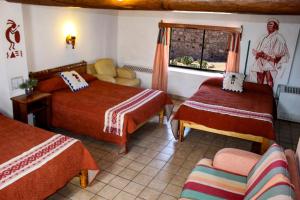 een hotelkamer met 2 bedden en een raam bij Hotel Divisadero Barrancas in El Divisadero