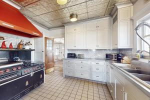 a large kitchen with white cabinets and a sink at Old Yacht Club Inn in Santa Barbara
