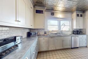 a kitchen with white cabinets and a sink at Old Yacht Club Inn in Santa Barbara