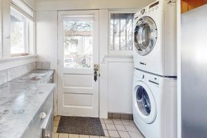 a white laundry room with a washer and dryer at Old Yacht Club Inn in Santa Barbara