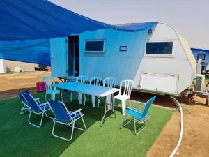 a picnic table and chairs in front of a trailer at שאשא קראון in Eilat