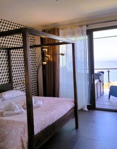 a bedroom with a bed with a view of the ocean at TorreNormanna Prestige House near Cefalù in Mandra Capreria
