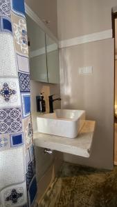 a white sink in a bathroom with blue and white tiles at Hanaia House in Stone Town