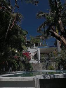 un edificio con palmeras y piscina en Quinta Santa Martha, en Cuernavaca
