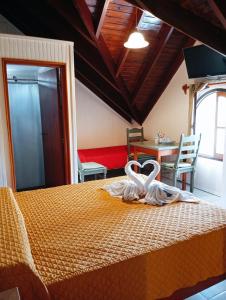 a bedroom with a bed with two swans on it at Apart Hotel Géminis in Termas del Daymán