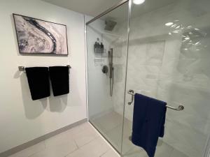 a bathroom with a glass shower with blue towels at Century City Cozy 2 Br 4 Sleeps Crib W Parking 505 in Los Angeles