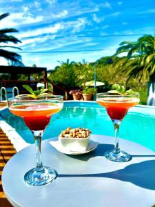 two cocktails on a table next to a pool at Caloura Water Accommodation in Lagoa