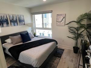 um quarto com uma cama e um vaso de plantas em Century City Cozy 2 Br 4 Sleeps Crib W Parking 505 em Los Angeles