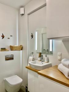 a white bathroom with a toilet and a sink at REMAR - Apartamenty nad Jeziorem Necko in Augustów