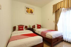 um quarto com 2 camas e uma janela em OYO 93789 Mbah Carik Homestay em Magelang