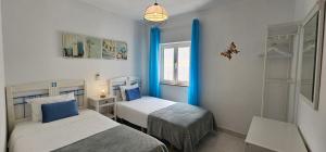 um quarto com duas camas e uma janela em Casa Alzira By ALzira em Albufeira