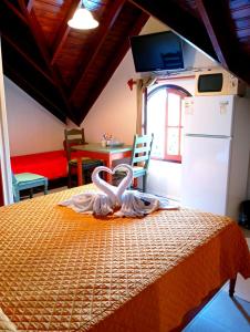 Dos cisnes están sentados en una cama en una habitación en Apart Hotel Géminis, en Termas del Daymán