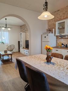 una cucina e una sala da pranzo con tavolo e sedie di Šimun&Jakov a Drinovci
