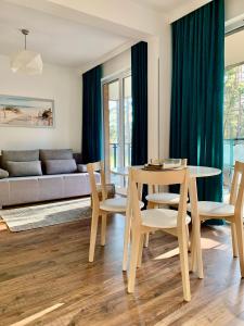 salon ze stołem, krzesłami i kanapą w obiekcie REMAR - Apartamenty nad Jeziorem Necko w mieście Augustów