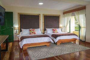 a bedroom with two beds and a rug at El Edén Country hotel y Club Residencial in Armenia