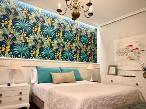 um quarto com duas camas e uma grande pintura na parede em El Patio de los Jazmines Boutique-House em Consuegra