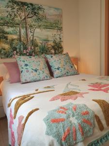 a bed with a comforter and pillows on it at Apartamento La Coveta de Guadalest in Guadalest