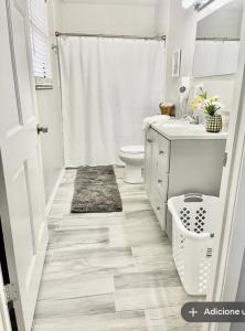 a white bathroom with a toilet and a sink at Tomoka River Guest House in Ormond Beach