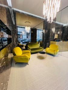 un soggiorno con sedie gialle e lampadario pendente di The Unique Hotel a Milano