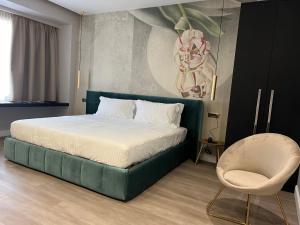 Un dormitorio con una cama verde y una silla en The Unique Hotel en Milán
