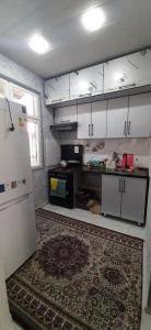 uma cozinha com armários brancos e um tapete em Chilanzar-21, Tashkent em Tashkent
