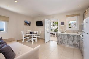 een woonkamer met een bank en een tafel en een keuken bij George Apartment in Vóthon