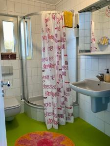 a bathroom with a shower curtain with writing on it at Casa Pippi Lotta in Gießen