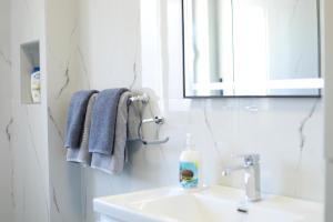 a bathroom with a sink and a mirror and towels at Central Fortuzi Apartment in Tirana +37 photos