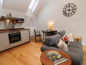 uma sala de estar com um sofá e uma mesa em The Loft at Lucott House em Bath