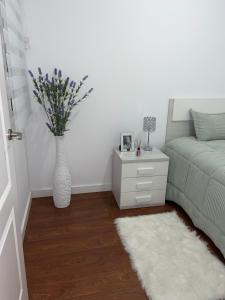 um quarto com uma cama e um vaso com flores em Apartamento Ferrer Gutierrez II em Barbastro