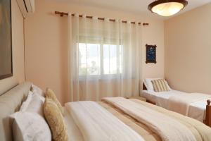 a living room with two beds and a window at Central Fortuzi Apartment in Tirana