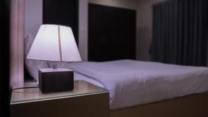 a lamp on a night stand next to a bed at Serenity Corner 4 BHK in Islamabad