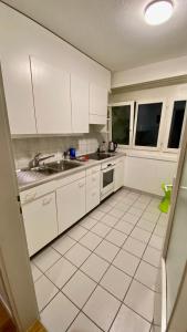 a kitchen with white cabinets and a sink at Gesamte Wohnung in Zurich in Kloten