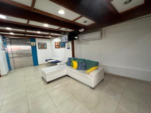 a living room with a white couch and a television at Edificio Santa Catalina in San Andrés