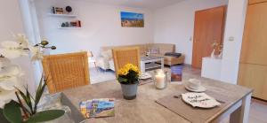 a living room with a table with flowers on it at Fewo Strandläufer Usedom im Grünen ruhig Terrasse Parkplatz in Ostseebad Karlshagen