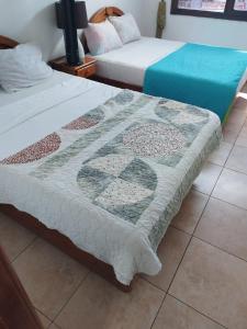 Hotel Canarias Paso Canoas في Canoas: سريرين يجلسون بجانب بعض في غرفة