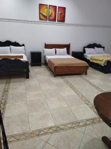 a bedroom with two beds and a tiled floor at Hotel Canarias Paso Canoas in Canoas
