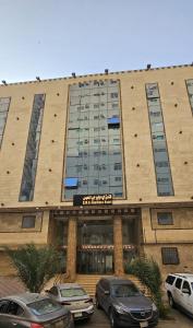 a large building with cars parked in front of it at EWG Mahbas Hotel in Makkah