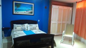 - une chambre bleue avec un lit et une chaise dans l'établissement APARTA-HOTEL YINNAM ARRIETA, à San Andrés