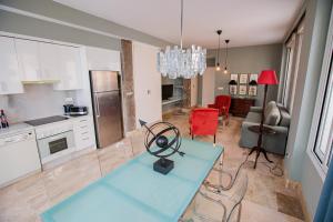 uma cozinha e sala de estar com uma mesa azul e cadeiras em Apartamento Arrayan em Sevilha